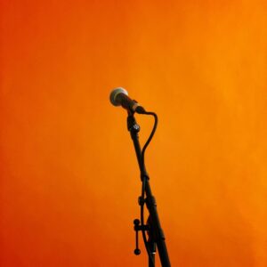 Microphone on a stand against an orange backdrop