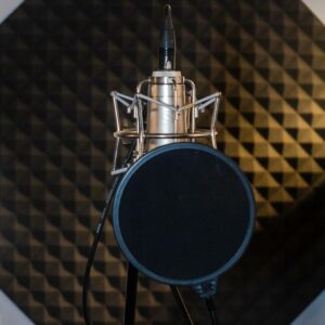 A microphone in a recording studio with a pop filter