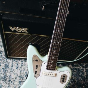 This photo shows a Fender Jaguar Guitar in front of a Vox combo amplifier.