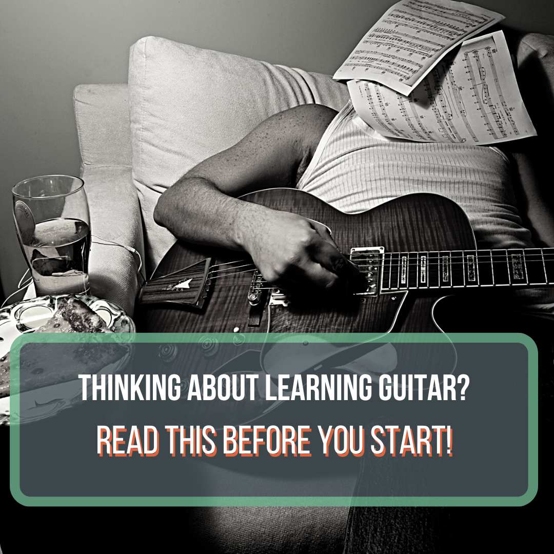This is a black and white photo of a man in a white shirt holding a guitar passed out. He has sheet music on his face and is sitting next to a glass of water and a pizza slice. This is supposed to be comical to show exhaustion from playing guitar. This is a featured image for a blog post "Is Guitar Hard to Learn?"