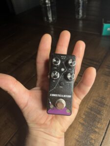 A picture of a hand holding the Pigtronix Constellator guitar pedal. This picture illustrates how small the pedal is.