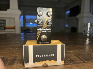 A close up picture of the Pigtronix Philosopher's Tone and Packaging. This picture helps you see the controls that are on the pedal. The controls are Volume, Sustain, Treble, and Mix.