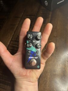 A picture of a hand holding the Pigtronix Space Rip guitar pedal. This picture illustrates how small the pedal is.